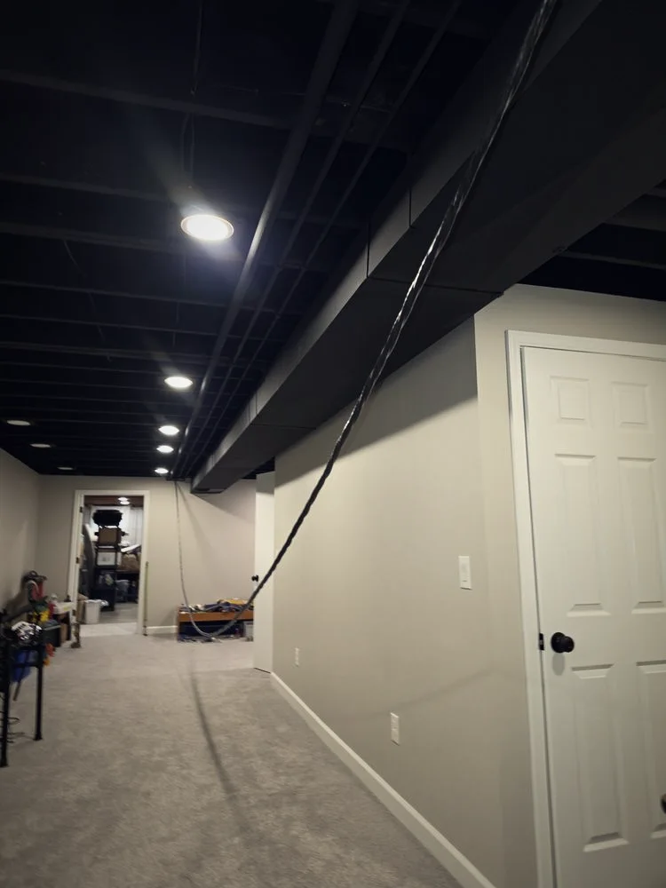 A finished basement hallway with new recessed lighting